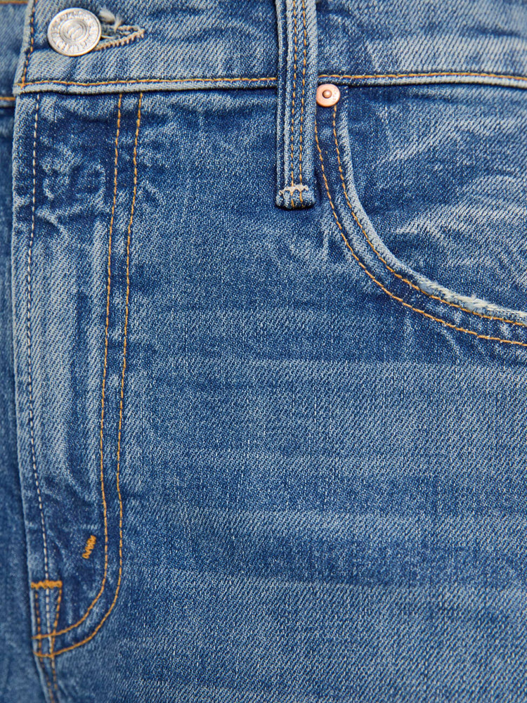 Swatch view of a woman in a mid blue high-waisted shorts have a low-slung fit and feature a wide leg that flares out at the knee, a zip fly, calf-length inseam and a frayed hem.
