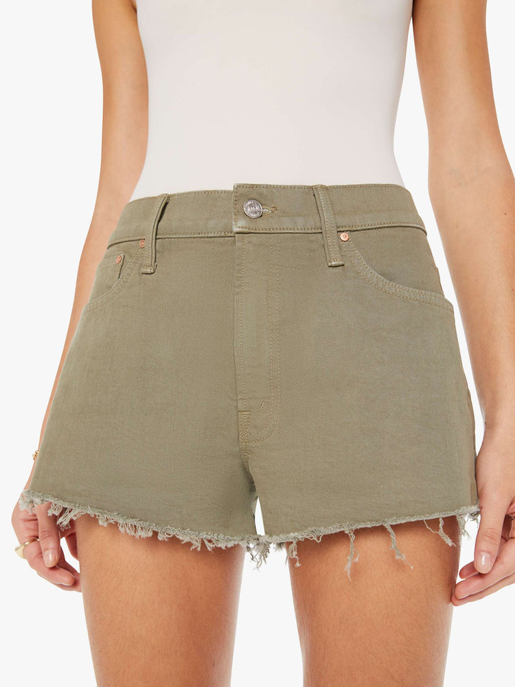 Front close up view of a greenish brown denim short featuring a relaxed mid rise and a short frayed hem.
