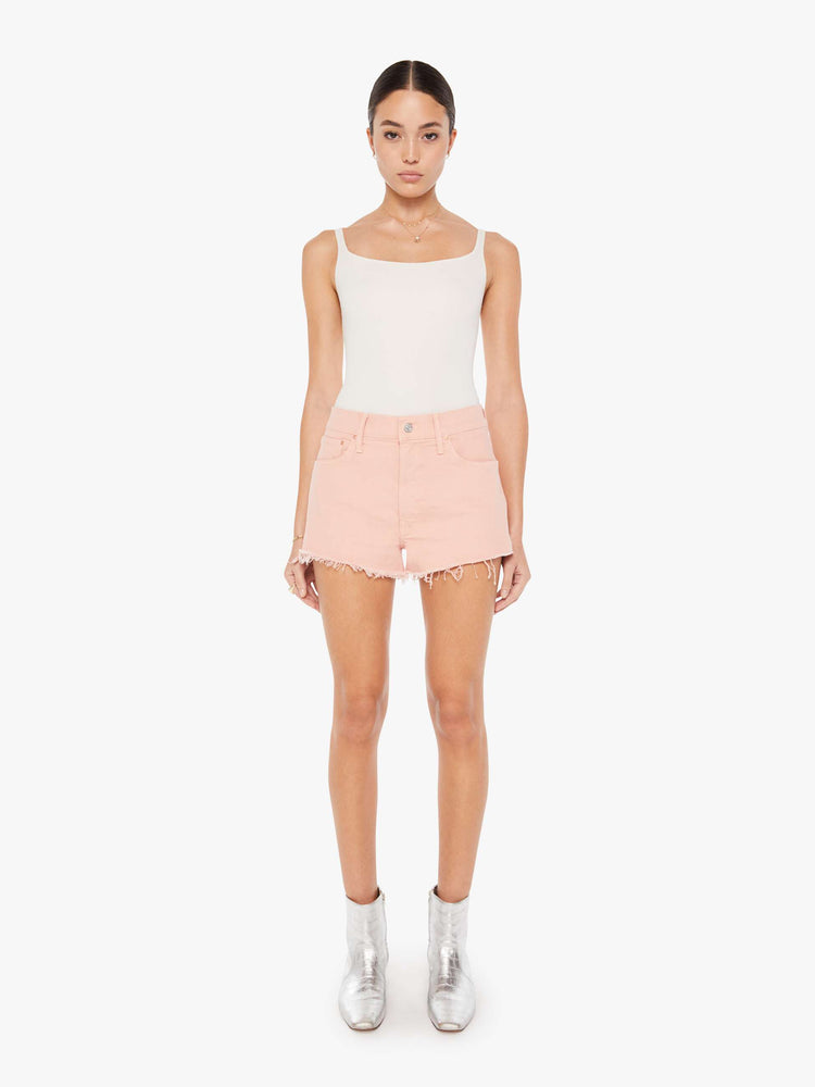 Front view of a faded pink denim short featuring a relaxed mid rise and a short frayed hem.
