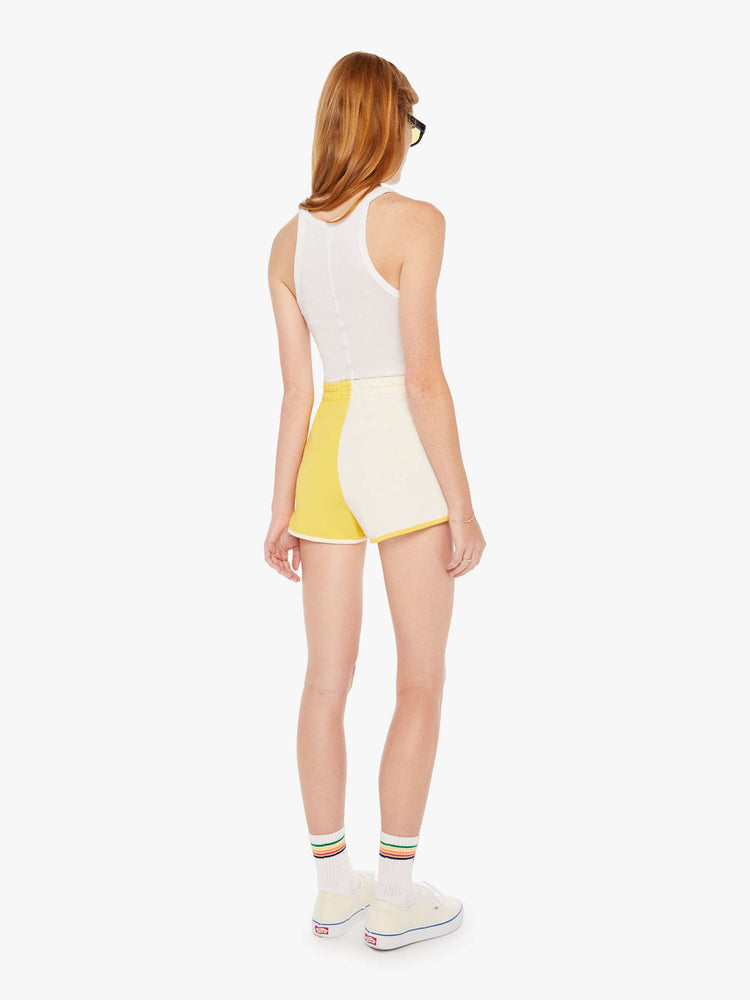 Back view of a womens yellow and white short featuring a high rise and elastic waist.
