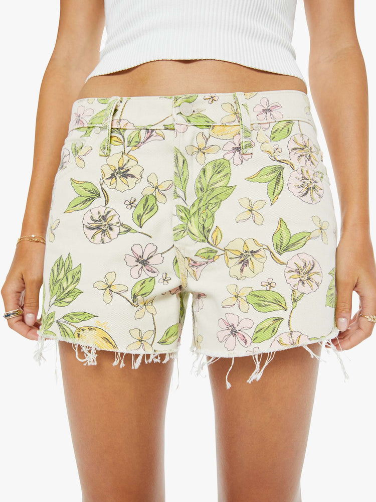 Close up view of a woman in blossom print  denim shorts are designed to sit lower on the hips with a loose leg, zip fly and 3.5-inch inseam with a frayed hem. 