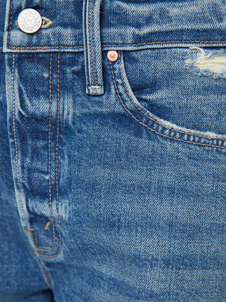 Swatch view of a woman in a mid blue lived in high-waisted denim shorts with a button fly, 4" inseam and a raw, chewed hem.
