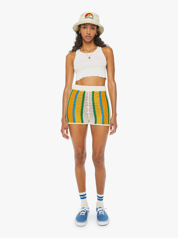 Front view of a woman in cream, orange, green and blue striped crochet shorts featuring delicate openwork details.