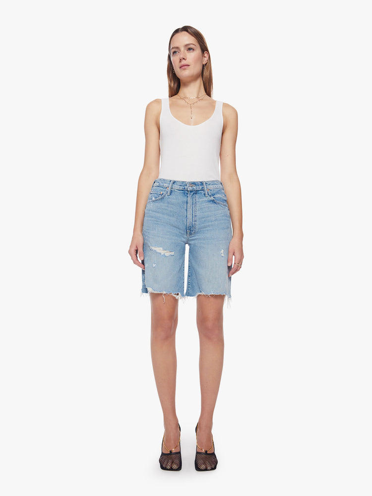 Front view of a woman light blue wash with bleach splatters bermuda short features a high rise, 9.25-inch inseam, wide leg and frayed hem.