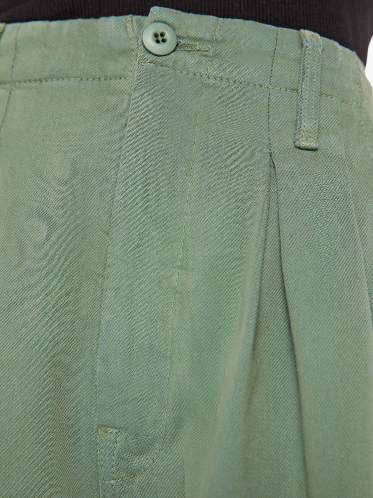 Close up swatch detail view of an army green short with front pleats.