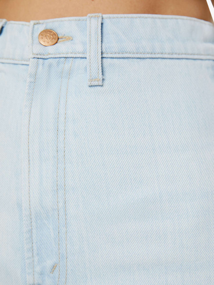 Swatch view of a woman in super high-rise light blue shorts that are designed with a 2-inch inseam, split, layered side seams, back slit pockets, curved hems and a pretzel-detailed button.
