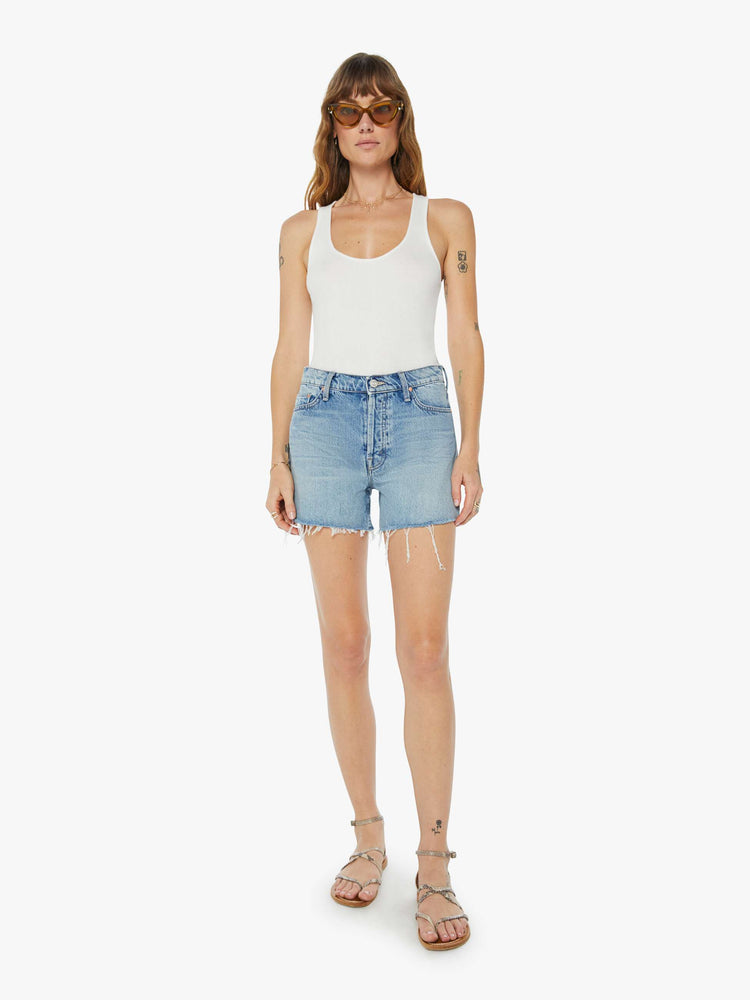 Front view of a womens light blue wash denim short featuring a high rise and frayed hem.