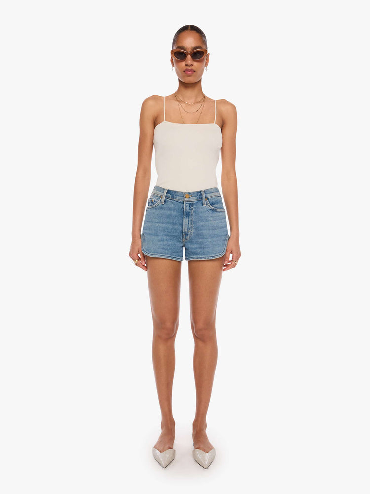 Front view of a woman in a light blue high-waisted jean shorts with a button fly and a curved, clean hem. 
