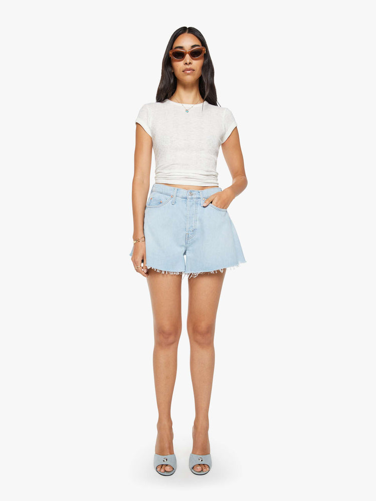 Front view of a woman in a super high-waisted denim shorts with a button fly, 3.25-inch inseam and a wide leg opening that flares out.