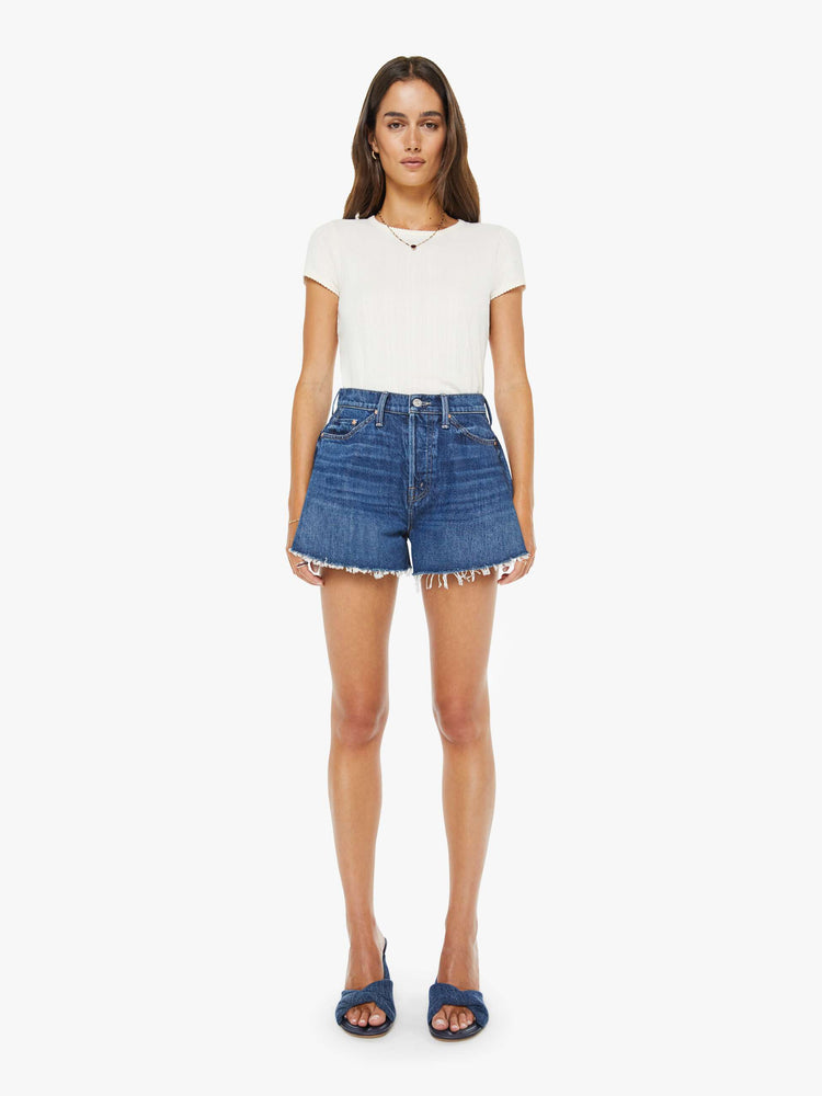 Front view of a woman in a super high-waisted denim shorts with a button fly, 3.25-inch inseam and a wide leg opening that flares out.
