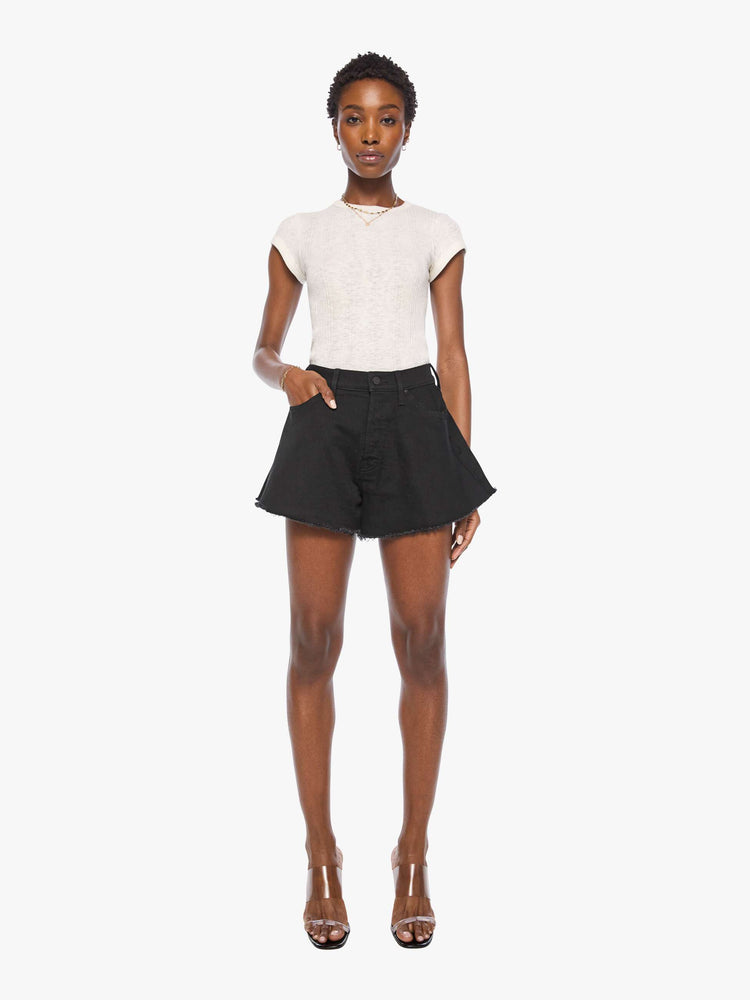 Front view of a woman in a black super high-waisted denim shorts with a button fly, 3.25-inch inseam and a wide leg opening that flares out.