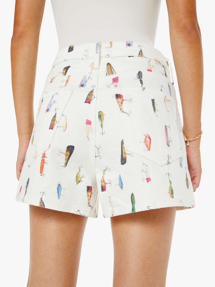 Close up view of a woman in an off-white with a faded fishing lure print super high waisted shorts with a 3.5-inch inseam, zip fly, clean hem and a loose fit.