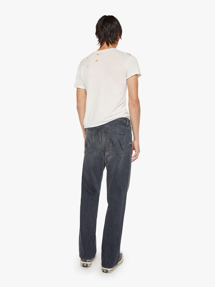 Back view of a man in faded black loose-fitting jean with a mid rise, zip fly, 31-inch inseam and a clean hem.