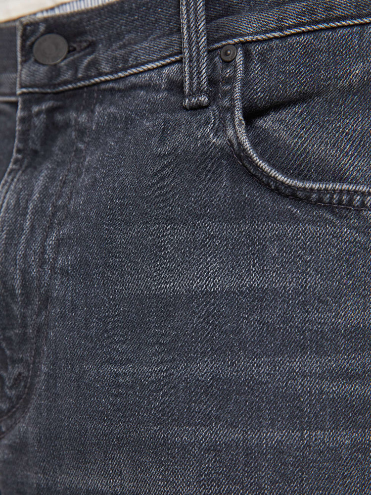 Swatch view of a man in faded black loose-fitting jean with a mid rise, zip fly, 31-inch inseam and a clean hem.