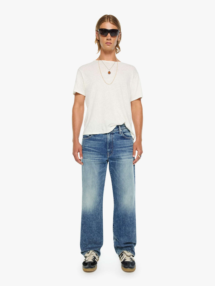 Front view of a woman in a loose-fitting jean with a mid rise, zip fly, 31-inch inseam and a clean hem.