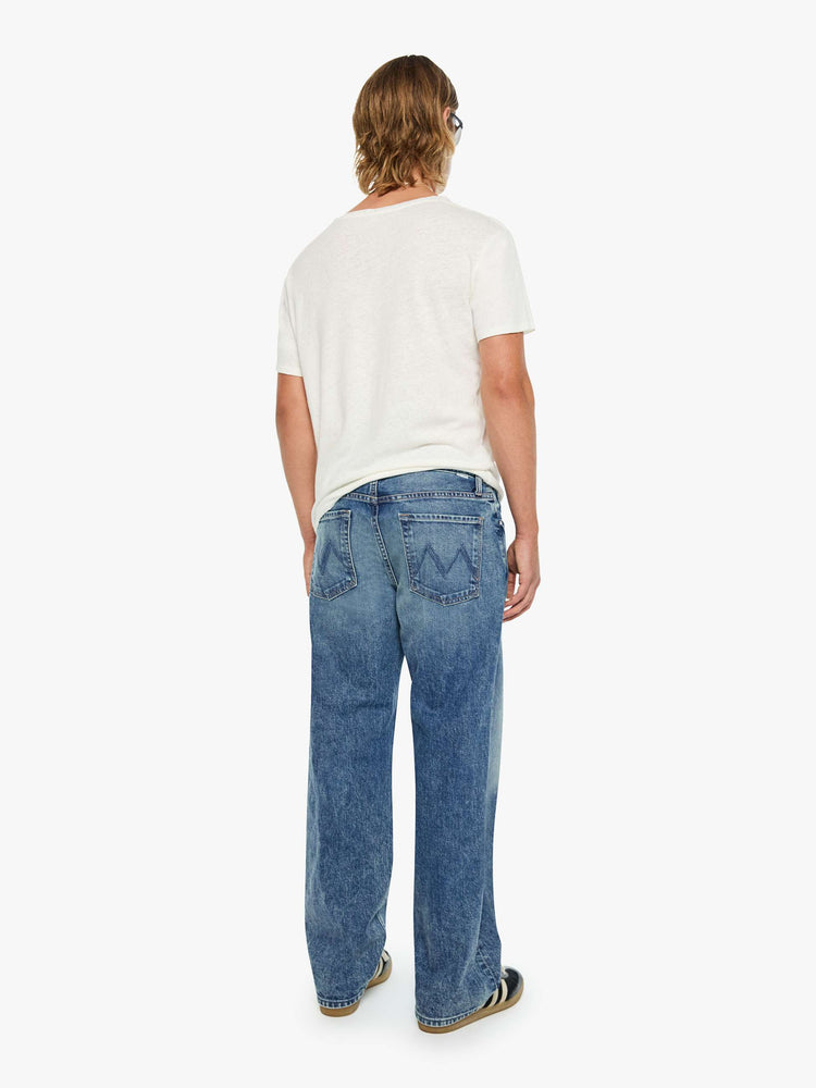 Back view of a woman in a loose-fitting jean with a mid rise, zip fly, 31-inch inseam and a clean hem.