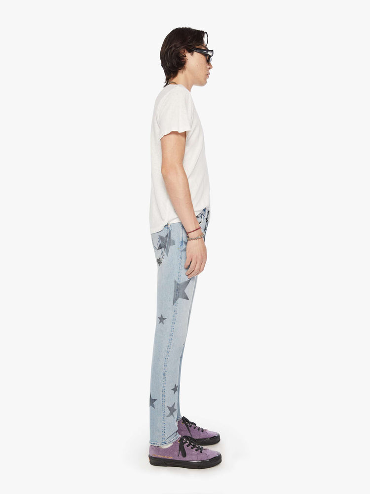 Side view of a mens slim-straight leg with a mid rise, 32-inch inseam and a clean hem in a light blue wash with faded stars.