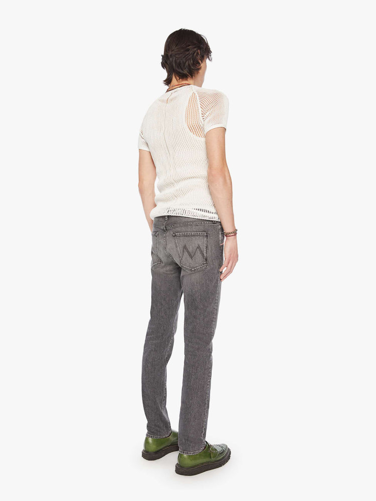 Back view of a men dark grey slim-straight leg with a mid rise, 32-inch inseam and a clean hem denim.