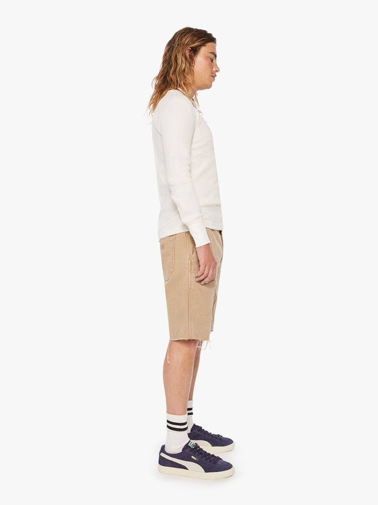 Side view of a men cut-off knee patches shorts are designed in a khaki hue.