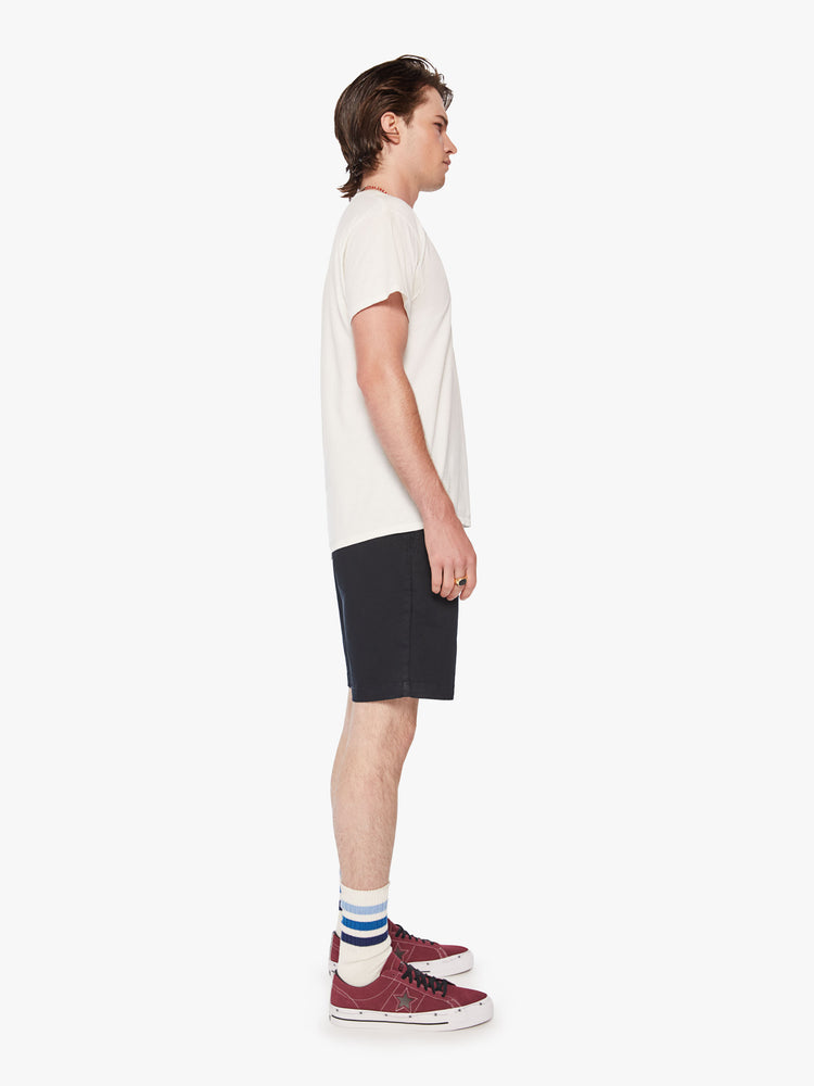 Side view of men jean short with a straight leg, slash pockets and an inseam above the knee in a dark navy hue.