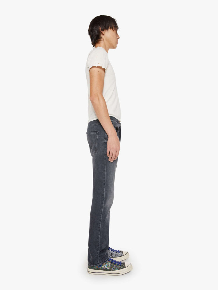 Side view of a man in faded black classic straight leg with a mid rise, button fly, 32-inch inseam and a clean hem.