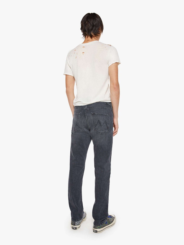Back view of a man in faded black classic straight leg with a mid rise, button fly, 32-inch inseam and a clean hem.
