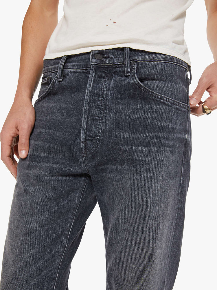 Close up view of a man in faded black classic straight leg with a mid rise, button fly, 32-inch inseam and a clean hem.