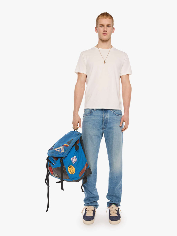 Front view of a man in light blue classic straight leg with a mid rise, button fly, 32-inch inseam and a clean hem.