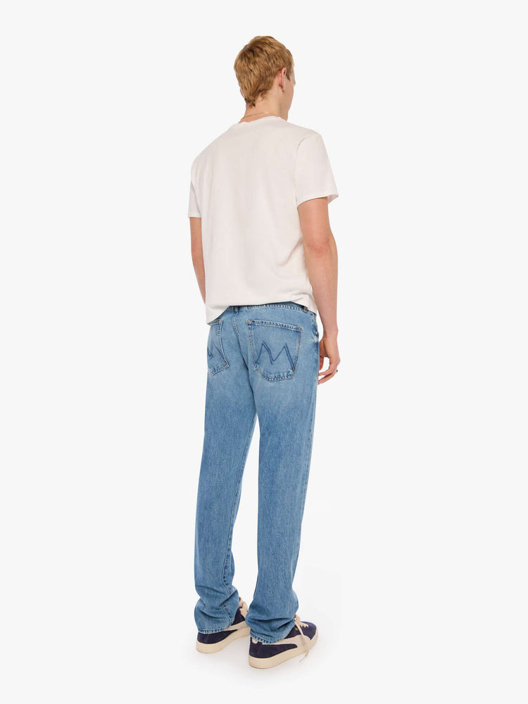 Full body view of a man in light blue classic straight leg with a mid rise, button fly, 32-inch inseam and a clean hem.