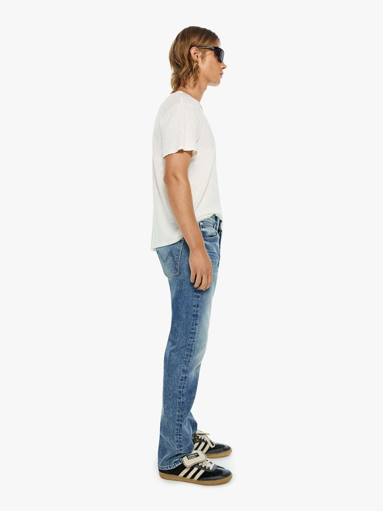 Side view of a man in a classic straight leg with a mid rise, button fly, 32-inch inseam and a clean hem.