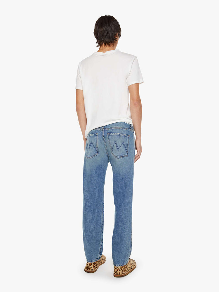 Back view of a man in  a straight-leg jean with a mid rise, zip fly, 31-inch inseam and a clean hem.