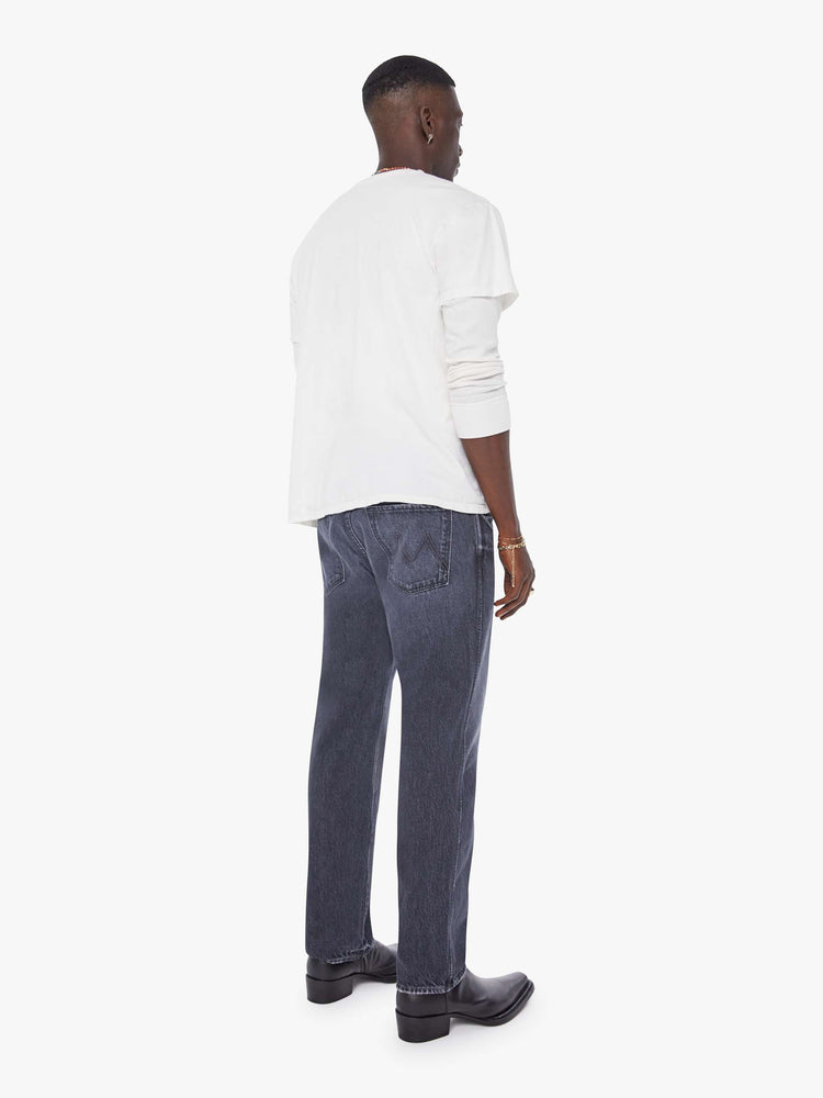 Back view of a man in a dark blue-grey straight-leg jean with a mid rise, zip fly, 30-inch inseam and a clean hem.