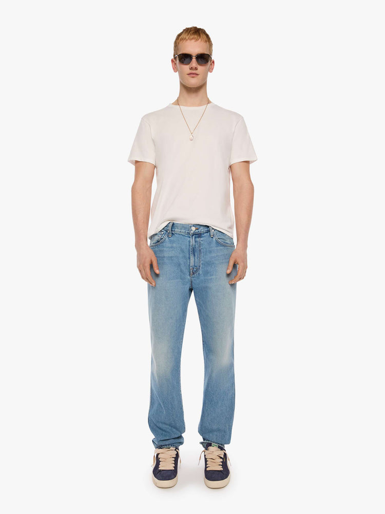 Front view of a man in a light blue straight-leg jean with a mid rise, zip fly, 30-inch inseam and a clean hem.