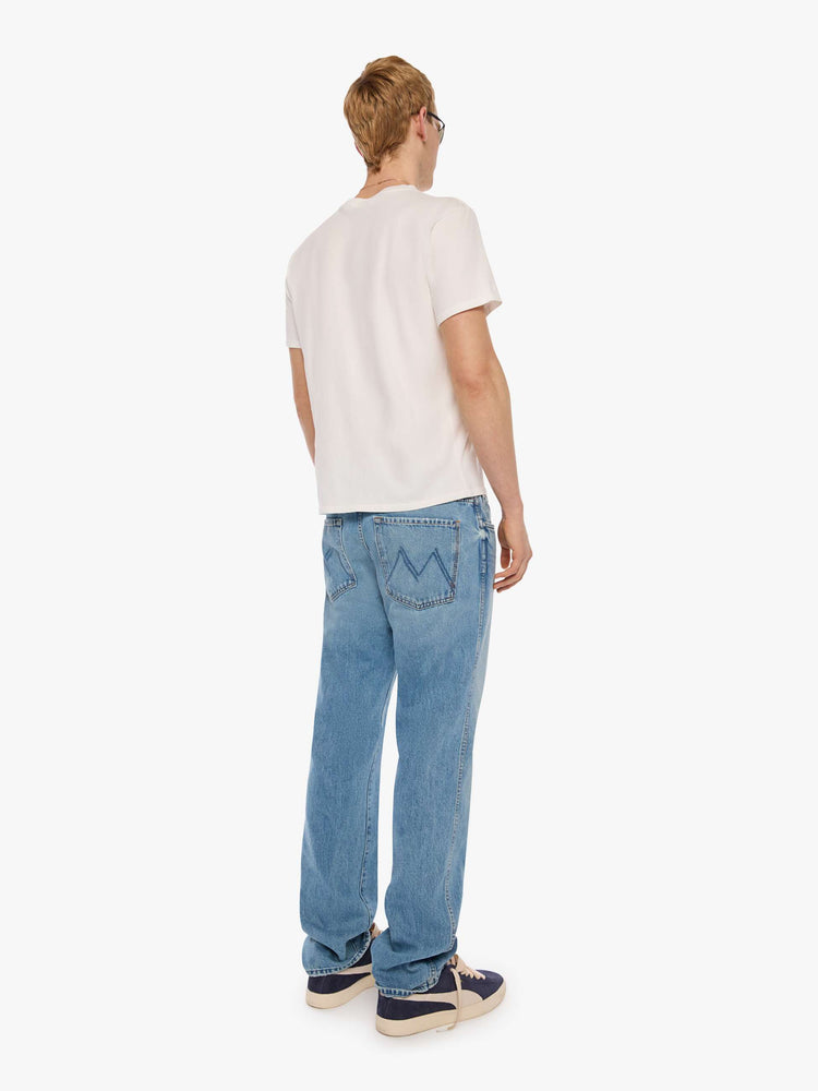 Back view of a man in a light blue straight-leg jean with a mid rise, zip fly, 30-inch inseam and a clean hem.