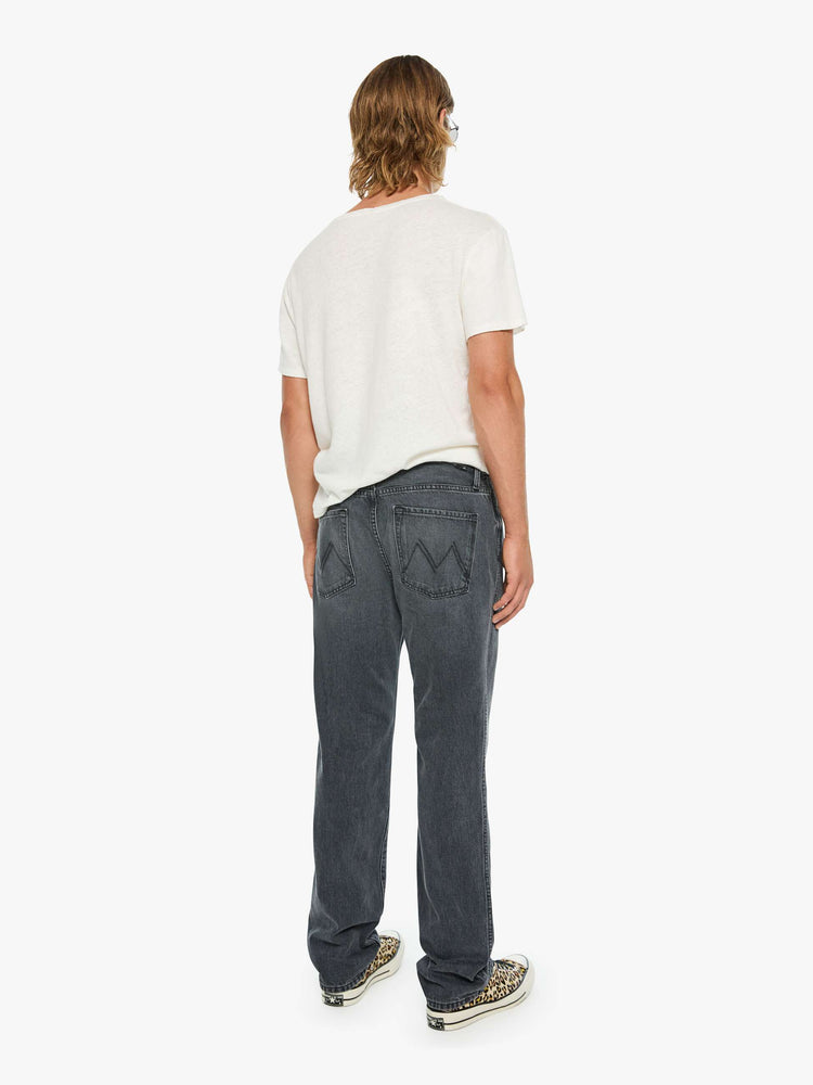 Back view of a man in a dark grey straight-leg jean with a mid rise, zip fly, 31-inch inseam and a clean hem.