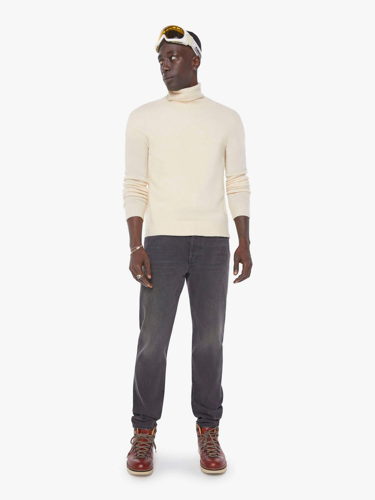 Front view of a man in a dark grey  standard straight leg with a mid rise, button fly and 32-inch inseam with a clean hem. 