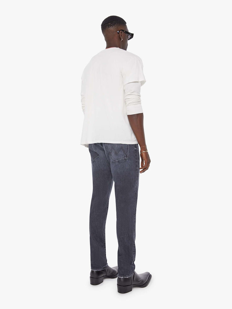 Back view of a man in a dark blue-grey  straight leg with a mid rise, button fly and 32-inch inseam with a clean hem. 