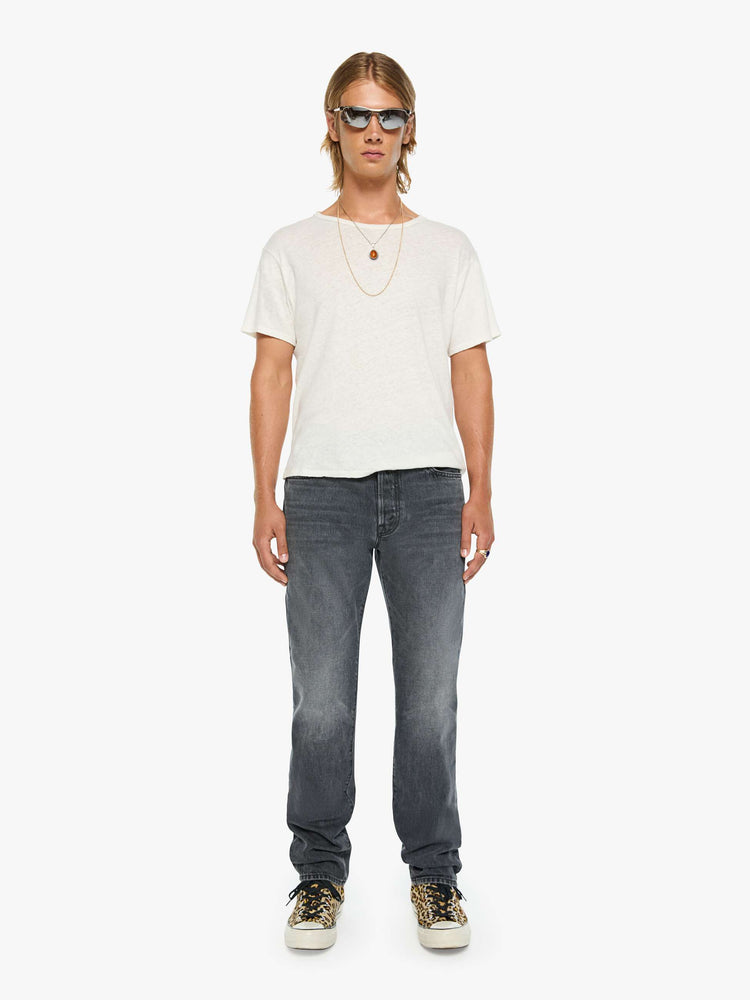 Front view of a man in a dark grey standard straight leg with a mid rise, button fly and 32-inch inseam with a clean hem.