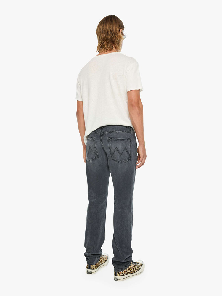 Back view of a man in a dark grey standard straight leg with a mid rise, button fly and 32-inch inseam with a clean hem.