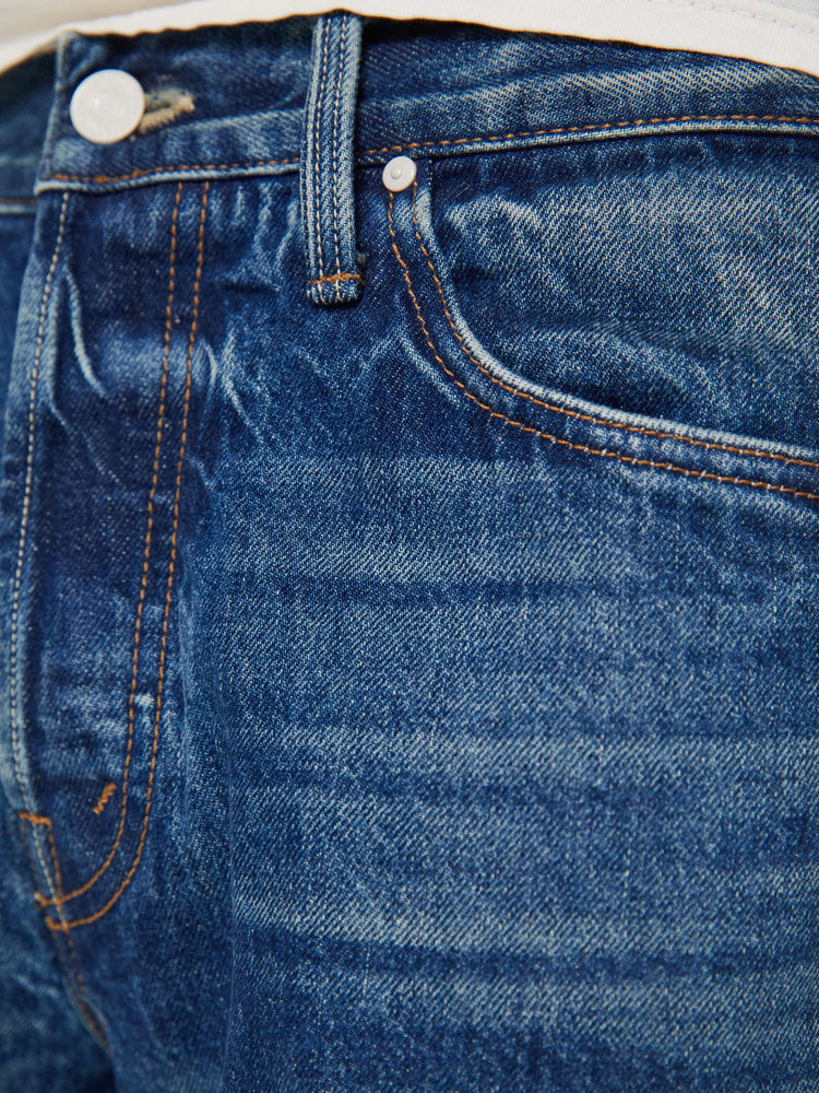 Swatch view of a man in a mid blue jean with a standard straight leg with a mid rise, button fly and 32-inch inseam with a clean hem.