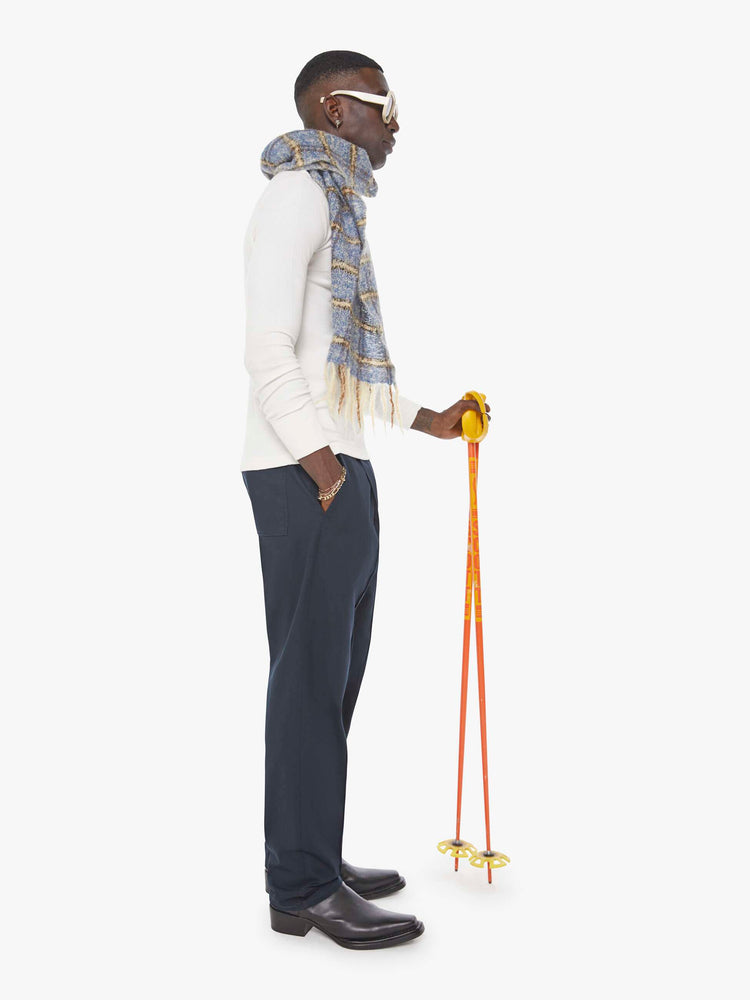 Side view of a man in  a blue jean with a mid rise, zip fly and loose leg.