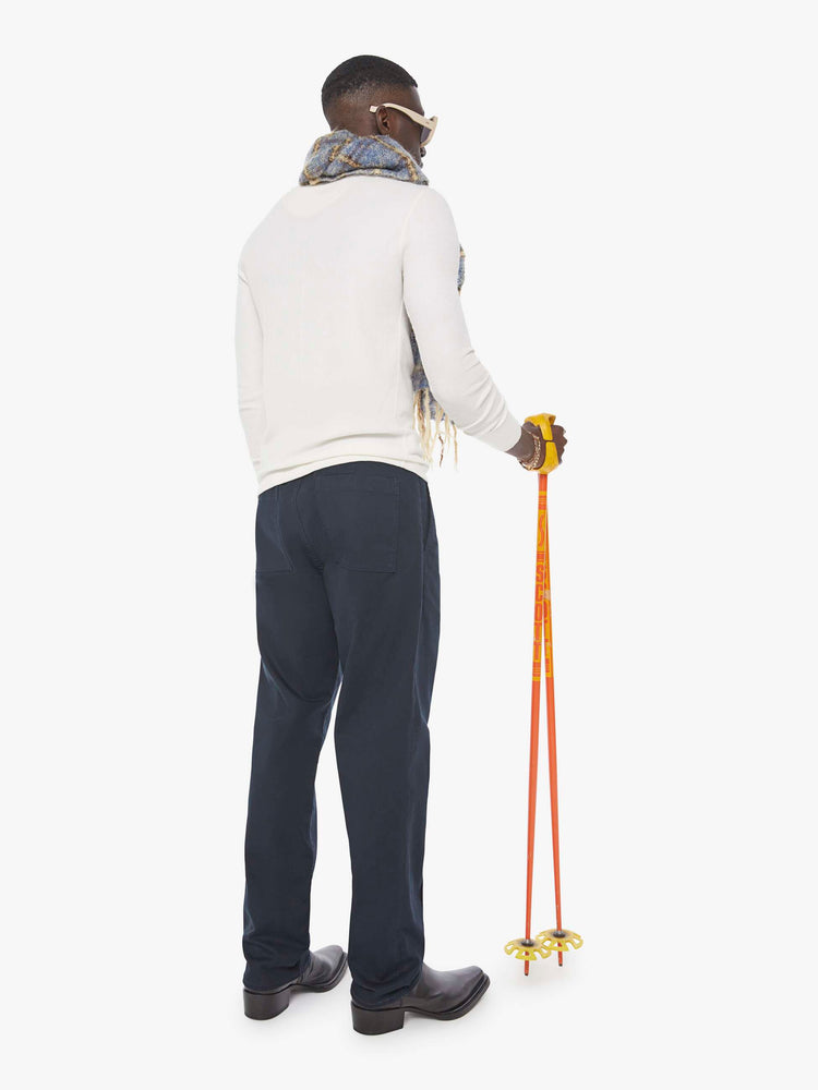 Back view of a man in  a blue jean with a mid rise, zip fly and loose leg.