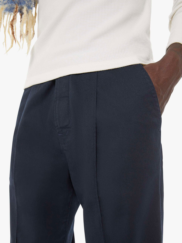 Close up view of a man in  a blue jean with a mid rise, zip fly and loose leg.