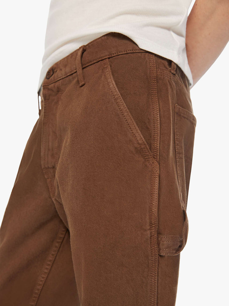 Waist close up view of a men classic pant with utilitarian pockets, a hammer loop and relaxed leg in a dark brown wash.