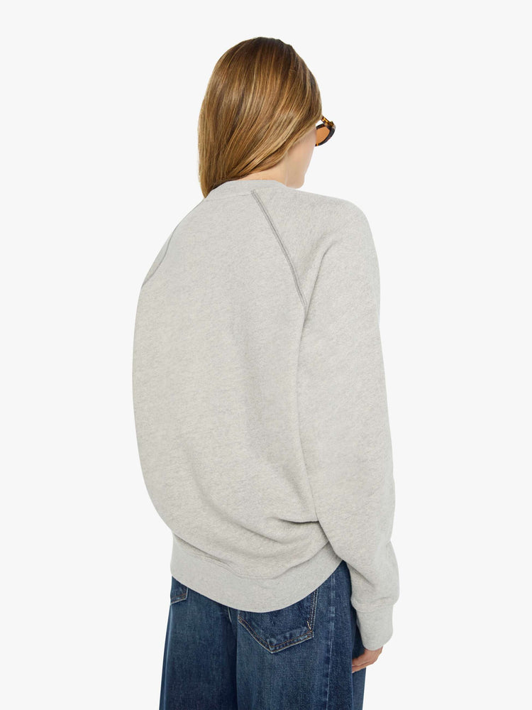 WOMAN back view heathered light grey sweatshirt features a faded snake graphic and block text on the front.