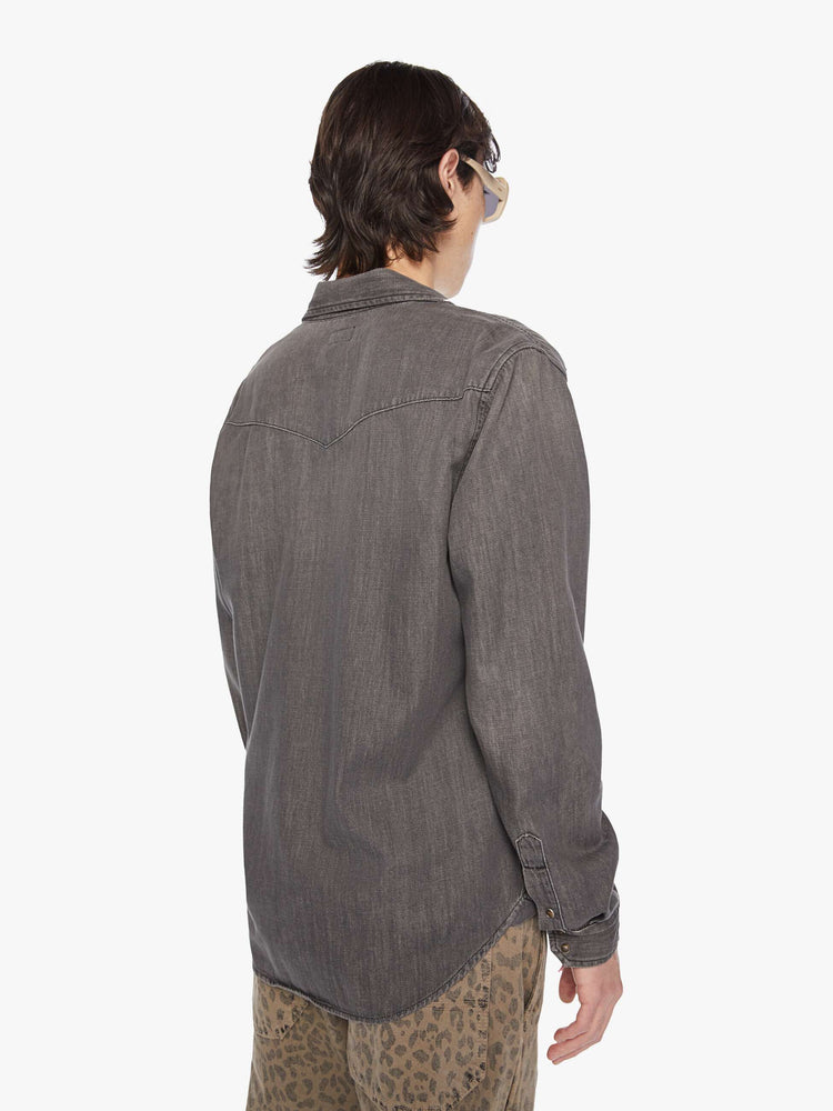 Back view of a men classic Western-inspired shirt with buttons, flap patch pockets, long sleeves and a curved hem in a dark black wash.
