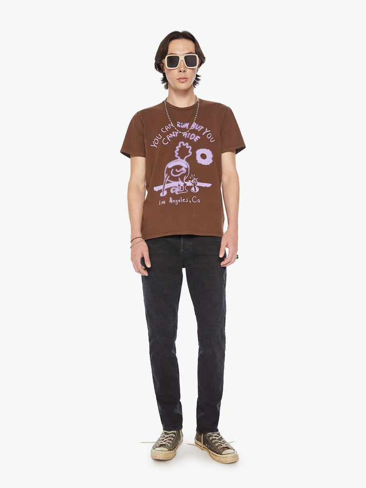 Full body view of a men classic crewneck tee with short sleeves in brown with lavender roadrunner graphic.