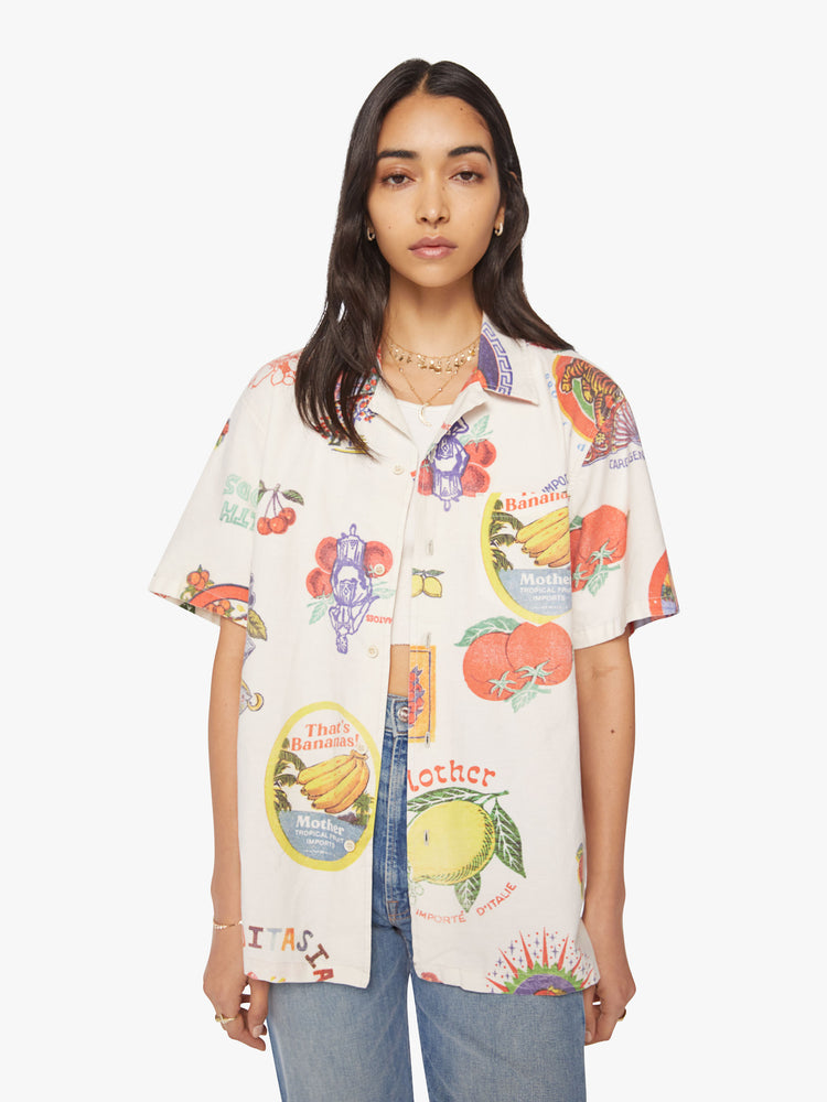 WOMEN short sleeve button-up with a patch pocket and slightly cropped hem in off white color with images of fruit labels.