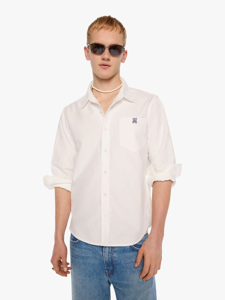 Front view of  man in the top is designed in white with a navy M embroidered on the chest.