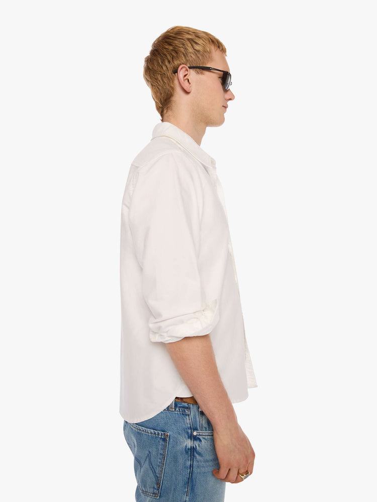 Side view of  man in the top is designed in white with a navy M embroidered on the chest.